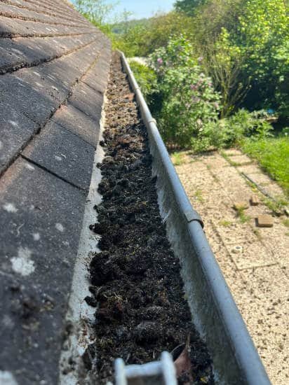 Gros plan sur gouttière remplie de boue dans le loiret
