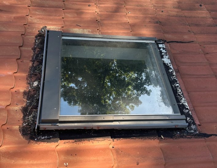 Un artisan Top Toitures finalise la pose d'une fenêtre de toit à Pithiviers.